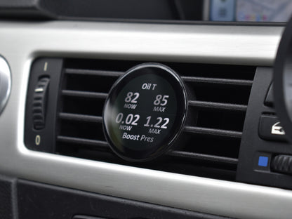 Ein guter Alt-Text für dieses Bild wäre:

"Ein COREDISPLAY Datendisplay, das in einen Lüftungsschlitz eingebaut ist. Der Bildschirm zeigt die aktuelle und maximale Öltemperatur sowie den aktuellen und maximalen Ladedruck an.
