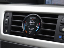 Ein COREDISPLAY GEN3 Datendisplay, eingebaut in den Lüftungsschlitz eines BMW 3er (E9x). Das Display zeigt aktuelle Leistungsdaten wie Geschwindigkeit (100 km/h), Ladedruck (1.06 bar), Kühlmitteltemperatur und die aktuelle PS-Zahl an.